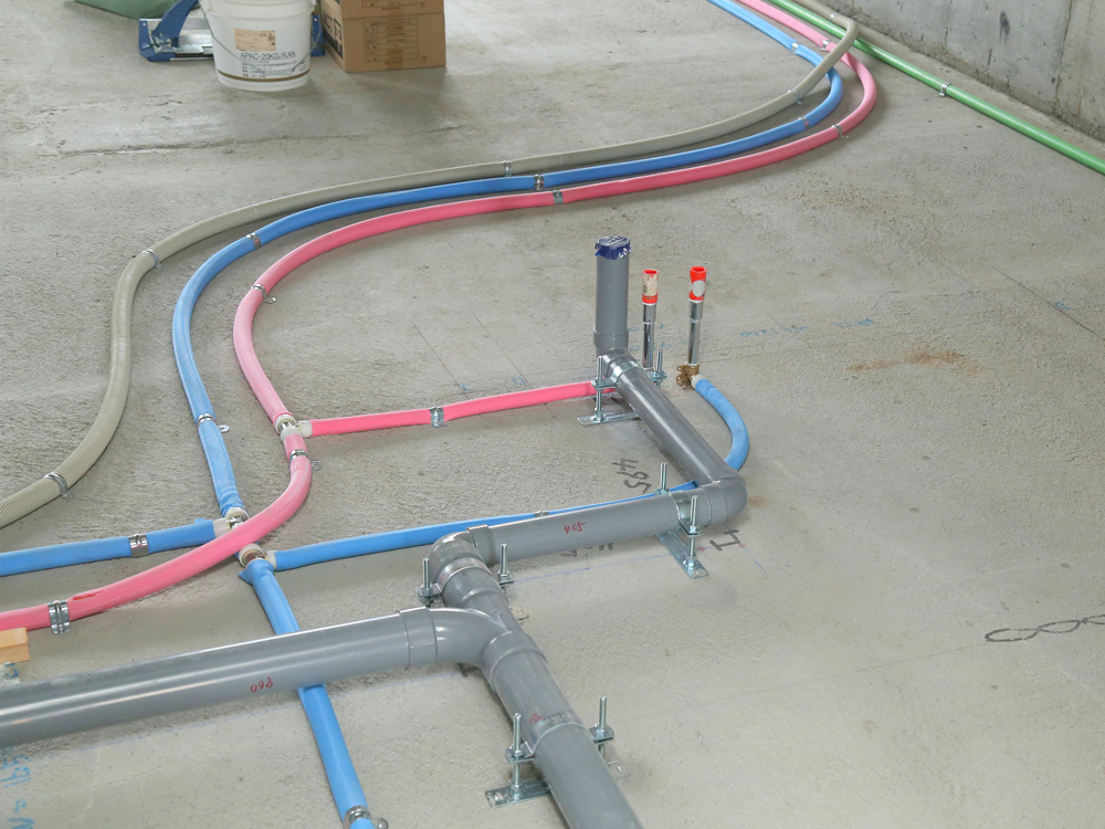 床下に設置された給水・給湯配管工事の様子